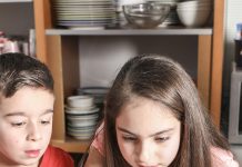 Kinder kleben Bilder ins WM-Album ein